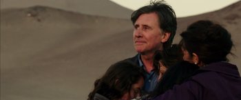 Movie still from “The 33” (2015), directed by Patricia Riggen – A person holding a dog; Close Up shot, Low angle