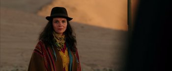 Movie still from “The 33” (2015), directed by Patricia Riggen – A woman wearing a hat standing in front of a hill; Medium shot, Over the shoulder angle