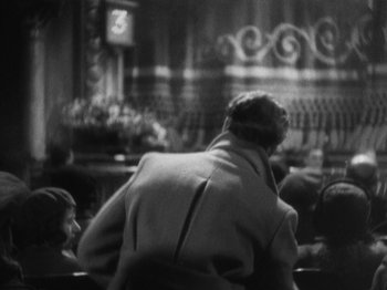 Movie still from “The 39 Steps” (1935), directed by Alfred Hitchcock – An older man sitting in front of two young children; Medium shot, Low angle