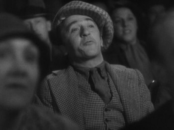 Movie still from “The 39 Steps” (1935), directed by Alfred Hitchcock – An older man wearing a hat in a crowd of people; Medium shot, Low angle