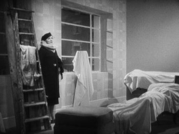 Movie still from “The 39 Steps” (1935), directed by Alfred Hitchcock – An old photo of a woman standing in front of a window; Wide shot, High angle