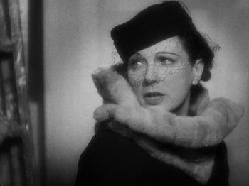 Movie still from “The 39 Steps” (1935), directed by Alfred Hitchcock – An old photo of a woman wearing a hat and a fur coat; Close Up shot, Low angle