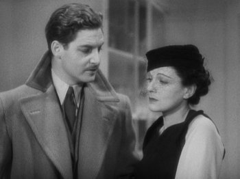 Movie still from “The 39 Steps” (1935), directed by Alfred Hitchcock – An old photo of a man and a woman standing next to each other; Medium shot, High angle