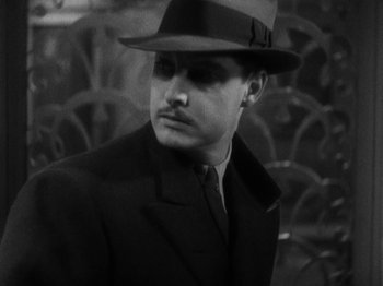 Movie still from “The 39 Steps” (1935), directed by Alfred Hitchcock – A black and white photo of a man wearing a hat; Close Up shot, High angle