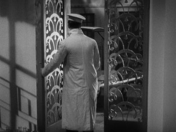 Movie still from “The 39 Steps” (1935), directed by Alfred Hitchcock – A black and white photo of a man carrying a tray of food; Medium shot, High angle