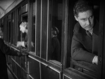 Movie still from “The 39 Steps” (1935), directed by Alfred Hitchcock – A black and white photo of a man looking out of a train window; Medium shot, Low angle