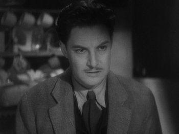 Movie still from “The 39 Steps” (1935), directed by Alfred Hitchcock – A black and white photo of a man wearing a suit and tie; Close Up shot, High angle
