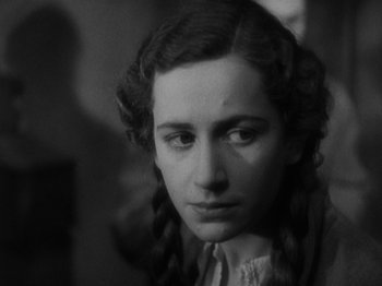 Movie still from “The 39 Steps” (1935), directed by Alfred Hitchcock – A young woman with long braids looking at the camera; Close Up shot, Low angle
