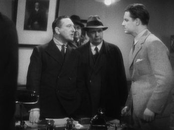 Movie still from “The 39 Steps” (1935), directed by Alfred Hitchcock – A group of men standing next to each other in a room; Medium shot, Low angle