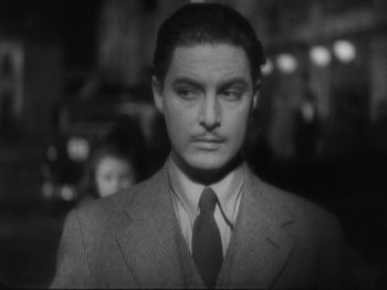 Movie still from “The 39 Steps” (1935), directed by Alfred Hitchcock – A black and white photo of a man in a suit and tie; Close Up shot, High angle