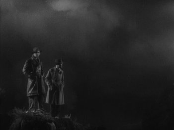 Movie still from “The 39 Steps” (1935), directed by Alfred Hitchcock – A black and white photo of two men standing on top of a hill; Extreme Wide shot, Low angle