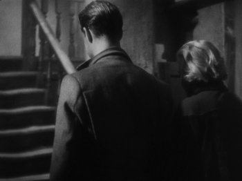 Movie still from “The 39 Steps” (1935), directed by Alfred Hitchcock – A man and a woman walking up a set of stairs; Medium shot, High angle