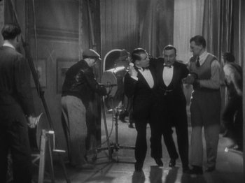 Movie still from “The 39 Steps” (1935), directed by Alfred Hitchcock – A black - and - white photo of two men in tuxedos; Wide shot, Low angle