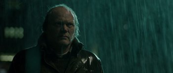 Movie still from “Department Q: The Absent One” (2014), directed by Mikkel Nørgaard – A person in a raincoat in the rain; Close Up shot, Low angle