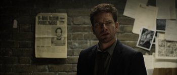 Movie still from “Department Q: The Absent One” (2014), directed by Mikkel Nørgaard – A man standing in front of a brick wall; Close Up shot, Over the shoulder angle