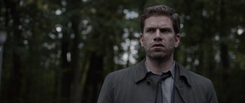 Movie still from “Department Q: The Absent One” (2014), directed by Mikkel Nørgaard – A person wearing a jacket and a tie; Close Up shot, Over the shoulder angle