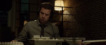 Movie still from “Department Q: The Absent One” (2014), directed by Mikkel Nørgaard – A man wearing headphones and looking down at a record player; Close Up shot, Low angle