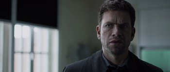 Movie still from “Department Q: The Absent One” (2014), directed by Mikkel Nørgaard – A person wearing a shirt and tie; Close Up shot, Over the shoulder angle