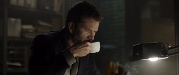 Movie still from “Department Q: The Absent One” (2014), directed by Mikkel Nørgaard – A man is drinking a cup of coffee while sitting at a table; Close Up shot, Low angle