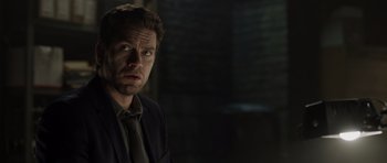 Movie still from “Department Q: The Absent One” (2014), directed by Mikkel Nørgaard – A person wearing a suit and tie; Close Up shot, Over the shoulder angle