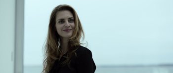 Movie still from “Department Q: The Absent One” (2014), directed by Mikkel Nørgaard – A beautiful woman with long brown hair standing in front of the ocean; Close Up shot, Low angle