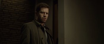 Movie still from “Department Q: The Absent One” (2014), directed by Mikkel Nørgaard – A man wearing a trench coat and tie; Close Up shot, Over the shoulder angle