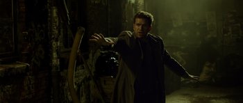 Movie still from “Department Q: The Absent One” (2014), directed by Mikkel Nørgaard – A man standing in the dark with his arms outstreched; Medium shot, Low angle