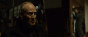 Movie still from “Department Q: The Absent One” (2014), directed by Mikkel Nørgaard – An older man in a black shirt and tie; Close Up shot, Low angle
