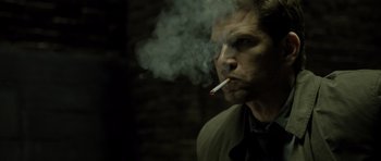 Movie still from “Department Q: The Absent One” (2014), directed by Mikkel Nørgaard – A man smoking a cigarette while wearing a jacket; Close Up shot, Over the shoulder angle