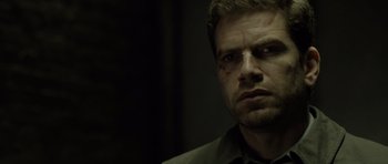 Movie still from “Department Q: The Absent One” (2014), directed by Mikkel Nørgaard – A person wearing a shirt and glasses; Close Up shot, Over the shoulder angle