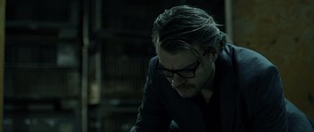 Movie still from “Department Q: The Absent One” (2014), directed by Mikkel Nørgaard – A man with long hair and glasses looking down; Close Up shot, Low angle