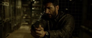 Movie still from “Department Q: The Absent One” (2014), directed by Mikkel Nørgaard – A man holding a gun while wearing a leather jacket; Close Up shot, Low angle