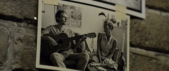 Movie still from “Department Q: The Absent One” (2014), directed by Mikkel Nørgaard – A man and a woman sitting on a couch playing a guitar; Close Up shot, Low angle