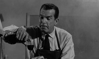 Movie still from “The Absent Minded Professor” (1961), directed by Robert Stevenson – A man sitting at a table holding a glass of wine; Close Up shot, Low angle