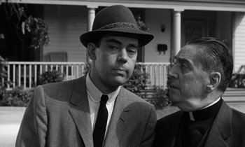 Movie still from “The Absent Minded Professor” (1961), directed by Robert Stevenson – A man wearing a suit and a hat talking to another man wearing a hat; Close Up shot, Over the shoulder angle