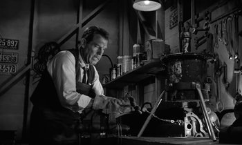 Movie still from “The Absent Minded Professor” (1961), directed by Robert Stevenson – A man in an old - fashioned dress shirt and tie working on a laptop computer; Medium shot, Low angle