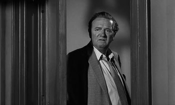 Movie still from “The Absent Minded Professor” (1961), directed by Robert Stevenson – Black and white photograph of a man in a suit and tie; Close Up shot, Low angle