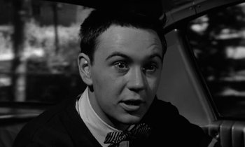 Movie still from “The Absent Minded Professor” (1961), directed by Robert Stevenson – A man with a bow tie is sitting in a car; Close Up shot, High angle