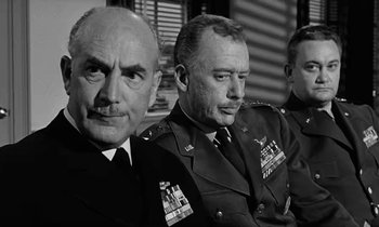 Movie still from “The Absent Minded Professor” (1961), directed by Robert Stevenson – A black - and - white photo of three men in military uniforms; Close Up shot, Low angle