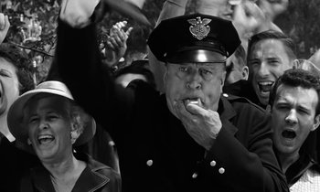 Movie still from “The Absent Minded Professor” (1961), directed by Robert Stevenson – An old man in a police uniform eating a piece of food; Medium shot, Low angle