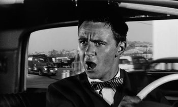 Movie still from “The Absent Minded Professor” (1961), directed by Robert Stevenson – A black and white photo of a man in a car; Close Up shot, Low angle