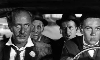Movie still from “The Absent Minded Professor” (1961), directed by Robert Stevenson – A black and white photo of a group of men in a car; Close Up shot, Low angle