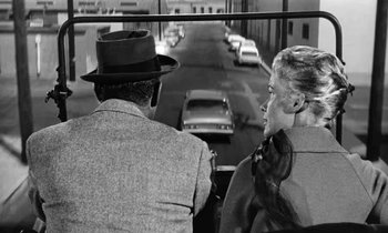 Movie still from “The Absent Minded Professor” (1961), directed by Robert Stevenson – A man and a woman riding a bike down a street; Medium shot, Over the shoulder angle
