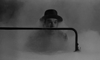 Movie still from “The Absent Minded Professor” (1961), directed by Robert Stevenson – A man in a hat is in a steam room; Medium shot, High angle