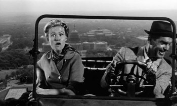 Movie still from “The Absent Minded Professor” (1961), directed by Robert Stevenson – An old photo of a woman driving a car; Medium shot, Low angle