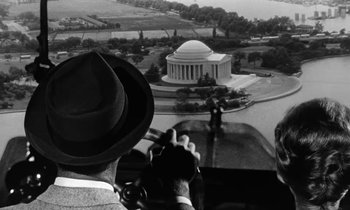 Movie still from “The Absent Minded Professor” (1961), directed by Robert Stevenson – A man with a hat on looking at the jefferson memorial; Extreme Wide shot, Low angle