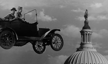 Movie still from “The Absent Minded Professor” (1961), directed by Robert Stevenson – An old car flying in the air near a building; Wide shot, Low angle