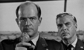 Movie still from “The Absent Minded Professor” (1961), directed by Robert Stevenson – A black and white photo of two men in military uniforms; Close Up shot, Low angle