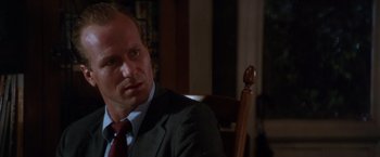 Movie still from “The Accidental Tourist” (1988), directed by Lawrence Kasdan – A person wearing a suit and tie; Close Up shot, Over the shoulder angle