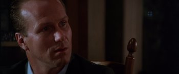 Movie still from “The Accidental Tourist” (1988), directed by Lawrence Kasdan – A person wearing a suit and tie; Close Up shot, Over the shoulder angle